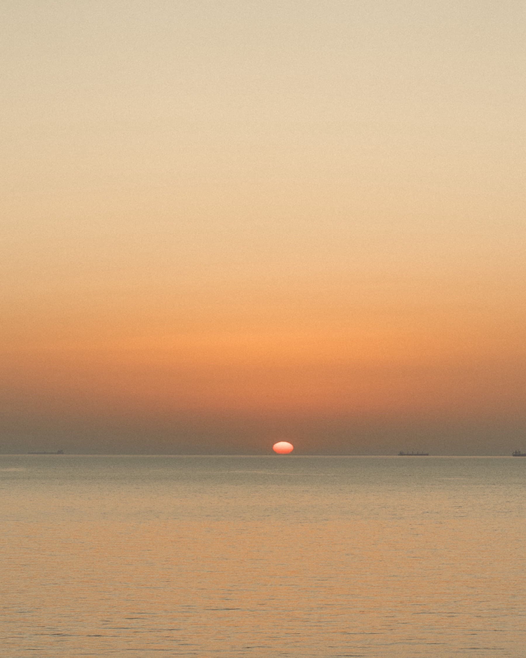 The sun setting on the horizon over a calm sea