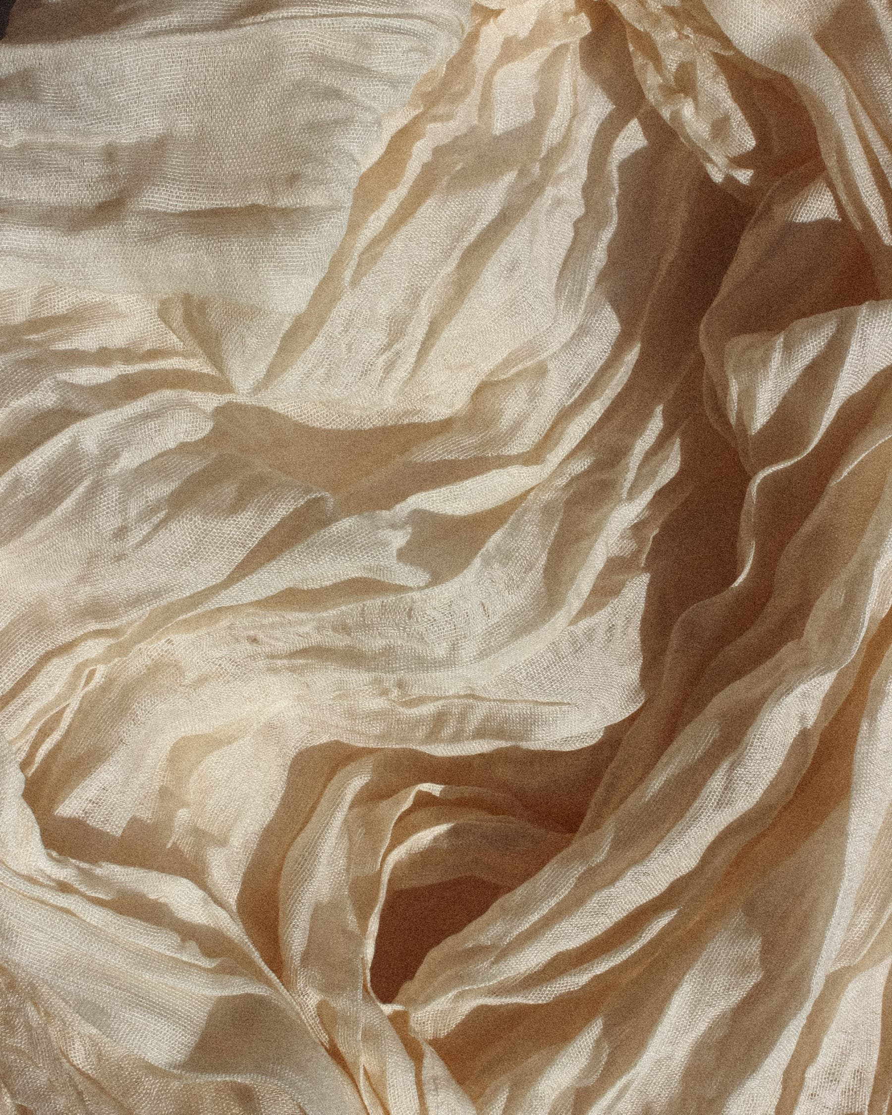 Folds of cream linen in warm morning light